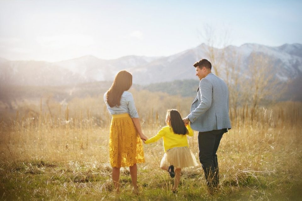 family holding hands walking away into a golden field - boulder family photographer