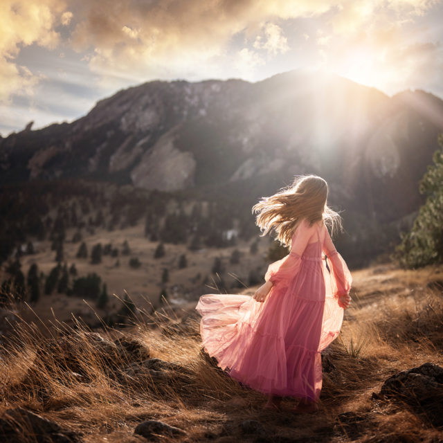 best photographer in Colorado - girl in pink gown on mountaintop at sunset